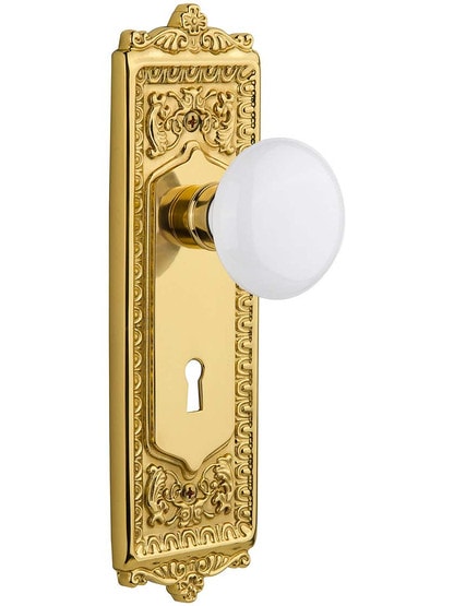 Egg and Dart Door Set with White Porcelain Knobs and Keyhole in Un-Lacquered Brass.